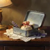 A tin box tied with ribbon on a lace doily.